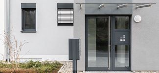 Ausschnitt Haus, Eingangstür Glas mit Alurahmen aus Aluminium, Türklingeln