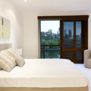 Innenaufnahme Schlafzimmer, Blick auf Balkonfenster mit Holzlammelen