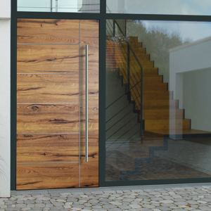 Ausschnitt eines Hauses, im Vordergrund Eingangstür aus Holz, links und darüber große Glaseinsetze