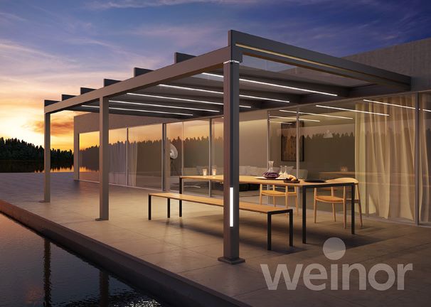 Luxushaus im Sonnenuntergang, geflieste Terrasse, Überdachung aus Aluminiumstangen und Glasdach
