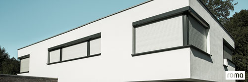 Ein modernes Bungalow im Detail mit unterschiedlichen Fenstergrößen und breiten ausgestattet mit Rollläden der Firma Roma.