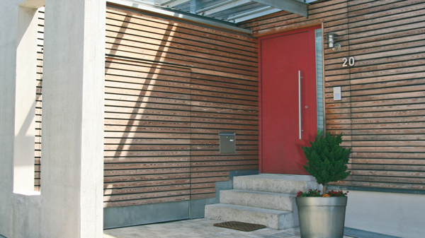 Weiße Eingangstür aus Aluminium eingefasst in vollformatige Glasscheiben rechts und links