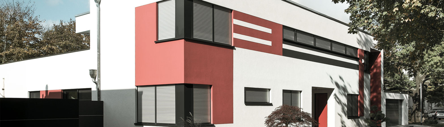 Ein modernes Bungalow mit unterschiedlichen Fenstergrößen und breiten ausgestattet mit Rollläden der Firma Roma.